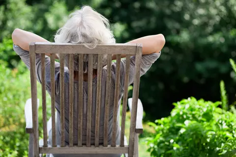 Frau liegt im Schatten auf einem Liegestuhl