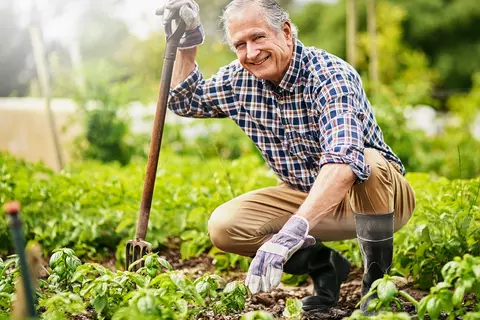 Gärtner kniend in seinem Garten
