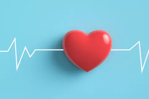 Ein rotes Herz und ein digitales Blutdruckmessgerät auf einem hellblauen Hintergrund, begleitet von einer weißen EKG-Linie, die die Bedeutung der Herzüberwachung hervorhebt.